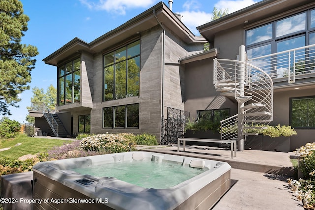 rear view of house featuring a patio area and a hot tub