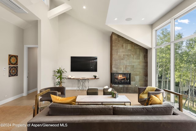 living room featuring a tile fireplace and high vaulted ceiling