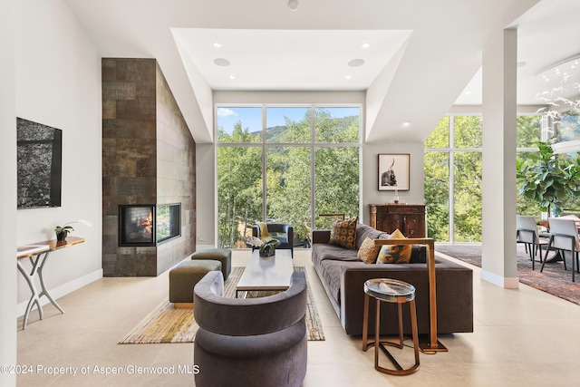 tiled living room featuring a towering ceiling and a tiled fireplace