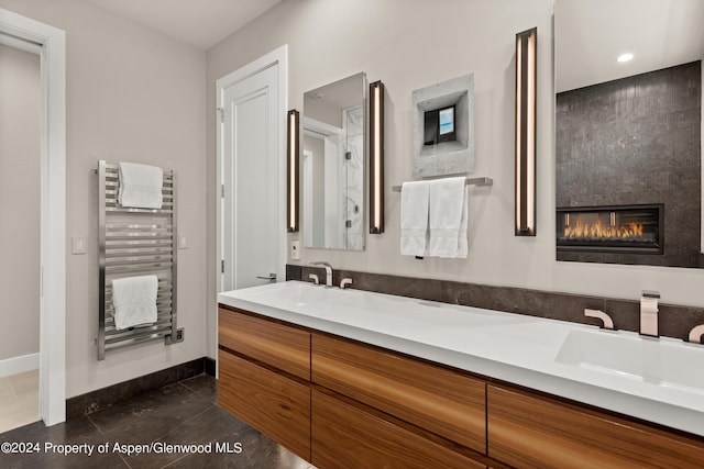 bathroom with radiator, a large fireplace, and vanity