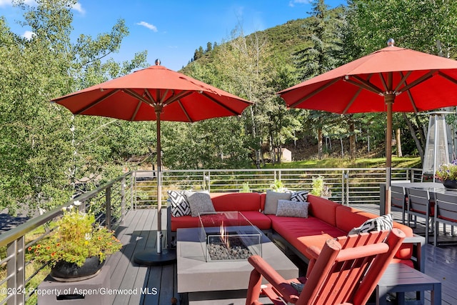 wooden deck featuring an outdoor living space with a fire pit