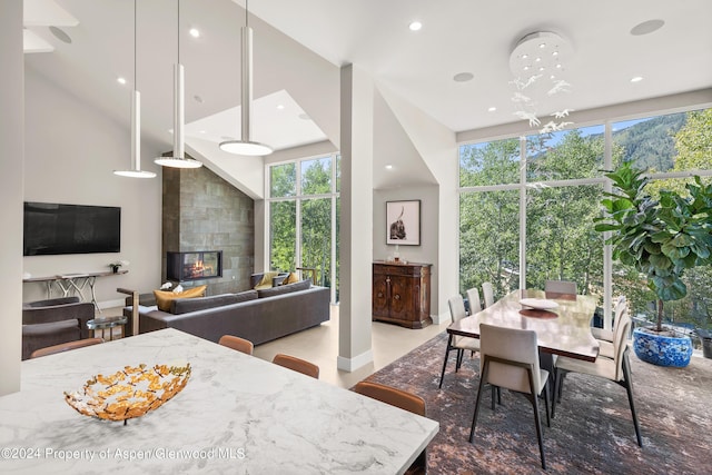 kitchen with a fireplace, decorative light fixtures, light stone countertops, and a chandelier