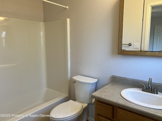 full bathroom featuring toilet, a textured wall, bathing tub / shower combination, and vanity