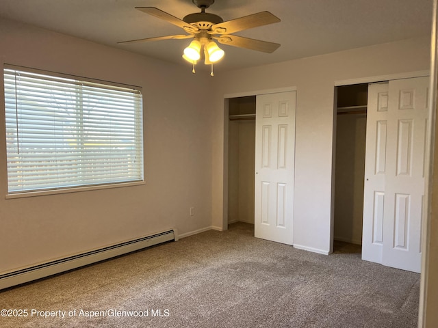 unfurnished bedroom featuring ceiling fan, a baseboard radiator, carpet floors, baseboards, and multiple closets