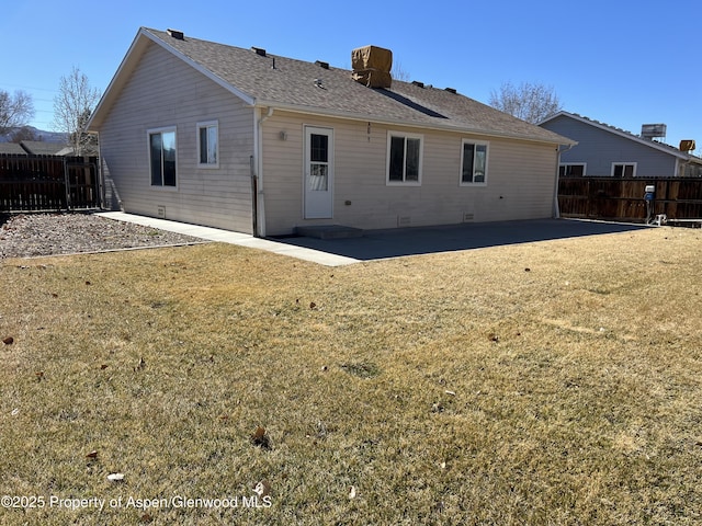 back of property featuring a fenced backyard, a shingled roof, a yard, crawl space, and a patio area