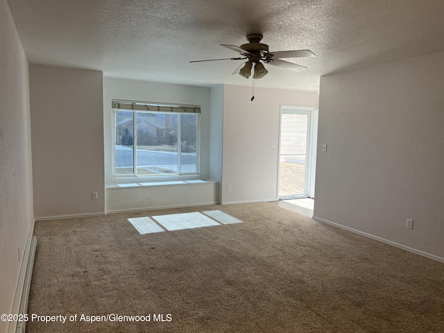 carpeted spare room featuring a ceiling fan, baseboards, a baseboard heating unit, and a textured ceiling