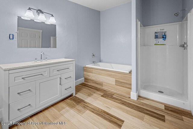 955 Sequoia Ave, Craig, CO 81625 - full bath with vanity, a garden tub, wood finished floors, and a shower