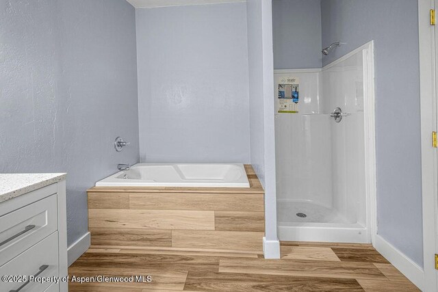 955 Sequoia Ave, Craig, CO 81625 - full bathroom featuring a garden tub, vanity, a shower, and wood finished floors
