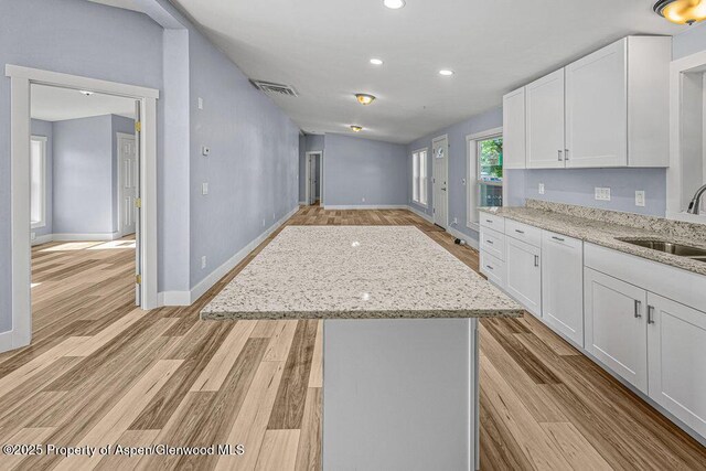 955 Sequoia Ave, Craig, CO 81625 - kitchen with a kitchen island, white cabinets, light wood finished floors, and recessed lighting