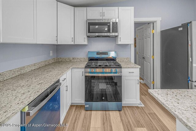 955 Sequoia Ave, Craig, CO 81625 - kitchen featuring stainless steel appliances, light wood-style flooring, white cabinetry, and light stone counters