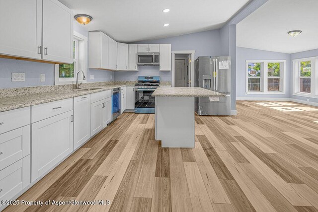 955 Sequoia Ave, Craig, CO 81625 - kitchen with appliances with stainless steel finishes, lofted ceiling, white cabinetry, light wood finished floors, and light stone countertops
