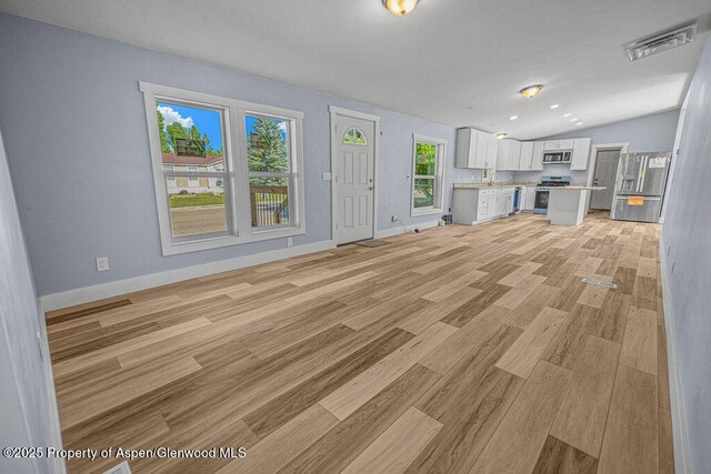 955 Sequoia Ave, Craig, CO 81625 - unfurnished living room with light wood-style flooring and vaulted ceiling