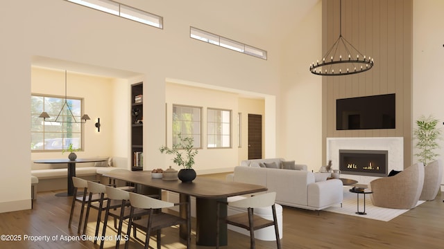 1042 Bald Eagle Way, Carbondale, CO 81623 - dining space featuring a towering ceiling, wood finished floors, a chandelier, and a warm lit fireplace