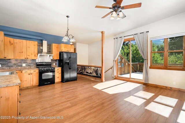 110 Easy St, Carbondale, CO 81623 - kitchen with black appliances, wall chimney range hood, light brown cabinetry, light countertops, and decorative backsplash