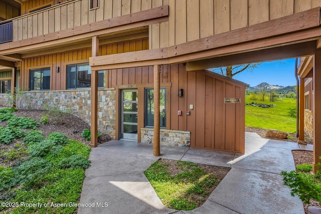 150 Snowmass Club Cir Unit 1623, Snowmass Village, CO 81615 - doorway to property with board and batten siding, a mountain view, and stone siding