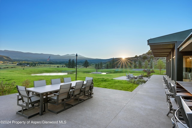 view of patio / terrace featuring a water and mountain view