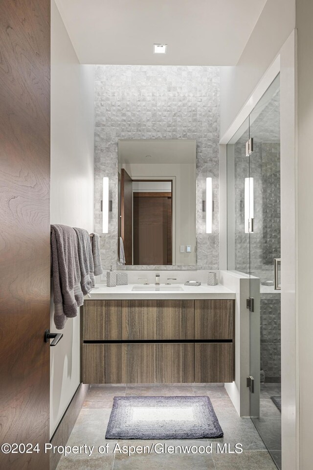 bathroom featuring vanity, tile patterned floors, and walk in shower