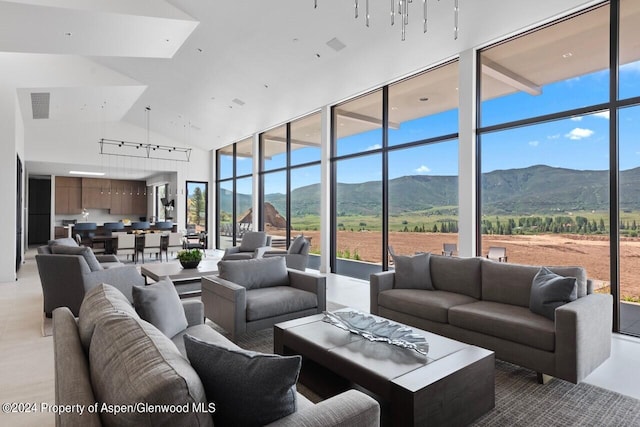 living room featuring a mountain view, expansive windows, a rural view, and high vaulted ceiling