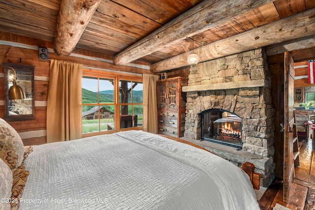 1350 Old Herron Rd, Basalt, CO 81621 - bedroom with a wooden ceiling with exposed beams, a stone fireplace, and a mountain view