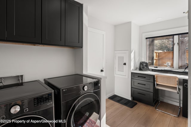 1625 Cooper Ave, Glenwood Springs, CO 81601 - clothes washing area with light wood-style floors, baseboards, washing machine and clothes dryer, and cabinet space