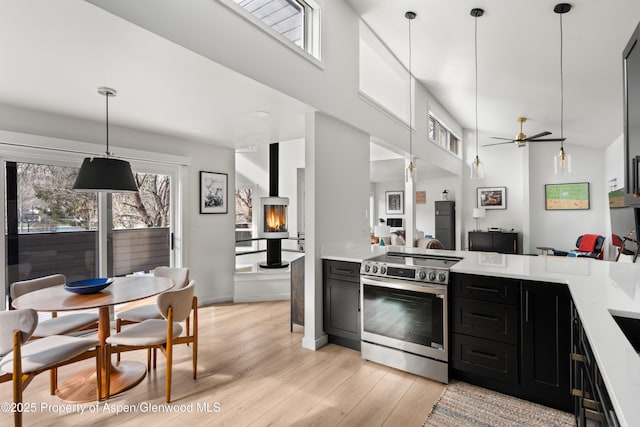 1625 Cooper Ave, Glenwood Springs, CO 81601 - kitchen featuring light wood-style floors, stainless steel range with electric cooktop, dark cabinets, light countertops, and open floor plan