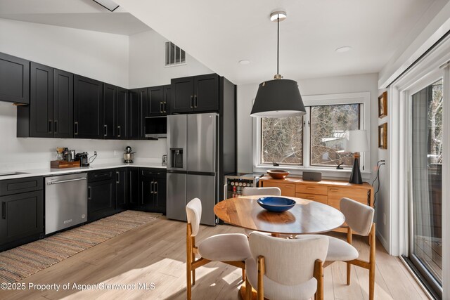 1625 Cooper Ave, Glenwood Springs, CO 81601 - kitchen with dark cabinets, light wood-type flooring, light countertops, visible vents, and appliances with stainless steel finishes