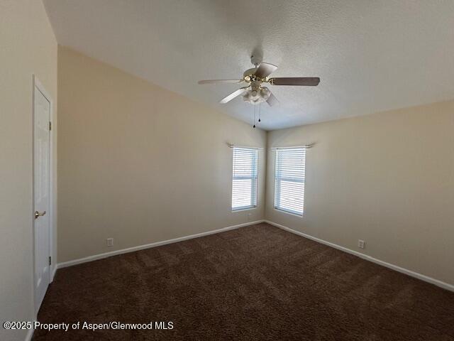 empty room featuring carpet flooring, baseboards, and a ceiling fan