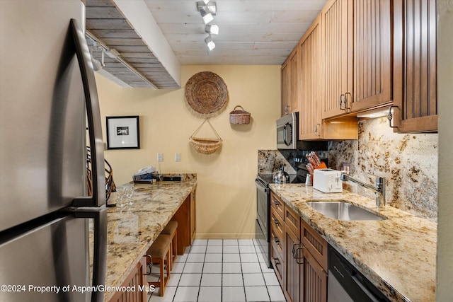 131 E Durant Ave Unit 202, Aspen, CO 81611 - kitchen with appliances with stainless steel finishes, a sink, decorative backsplash, light tile patterned floors, and baseboards