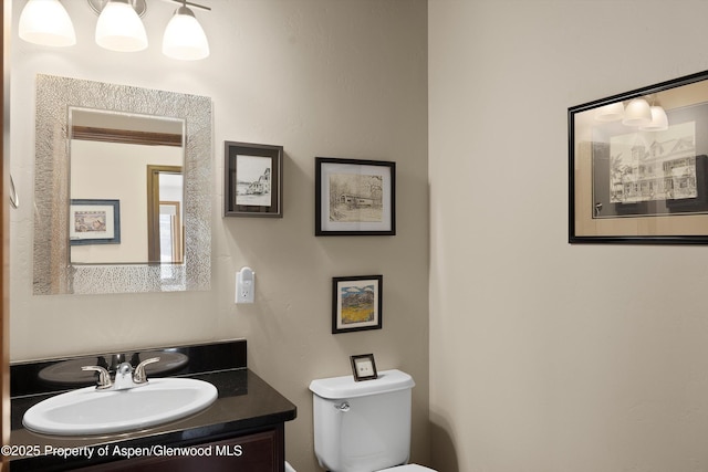 half bath featuring vanity and toilet