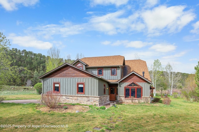 craftsman house featuring a shingled roof, board and batten siding, a front lawn, and stone siding
