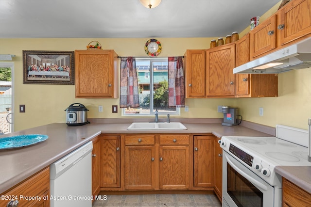 kitchen with sink, white appliances, and exhaust hood