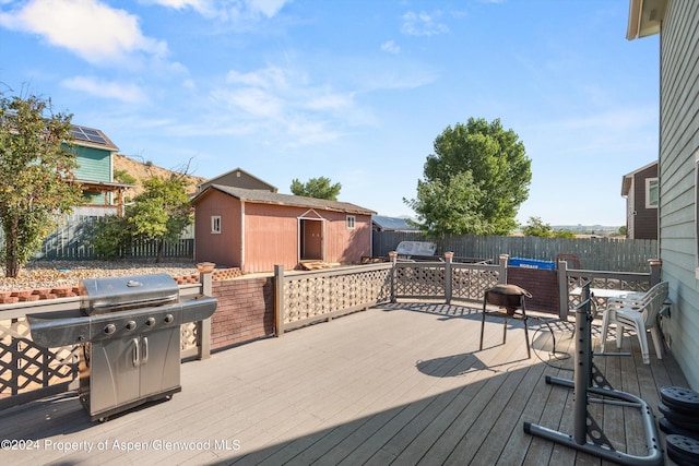 wooden deck with grilling area and a storage shed