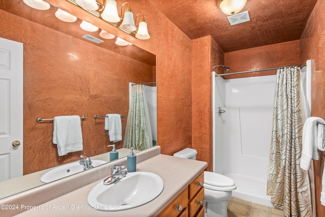 bathroom featuring vanity, toilet, and curtained shower