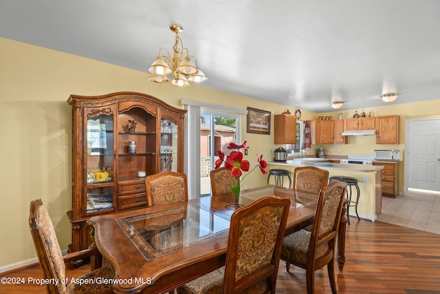 dining area with a chandelier, hardwood / wood-style floors, and sink