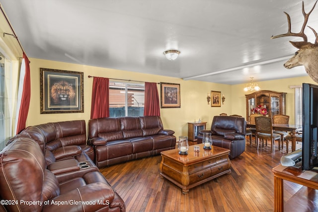 living room featuring a notable chandelier and dark hardwood / wood-style flooring