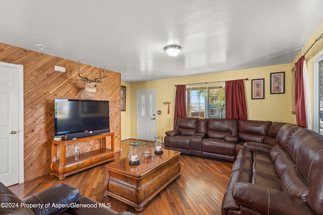 living room with hardwood / wood-style floors and wooden walls