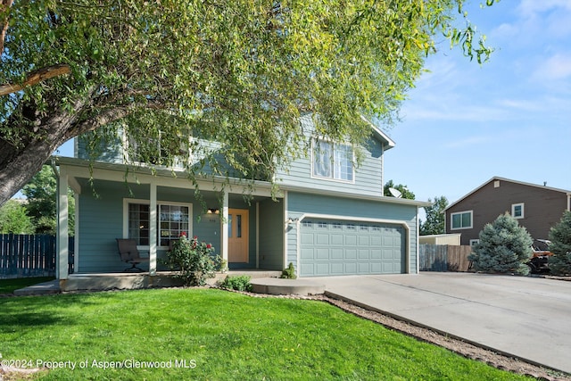 view of front of home featuring a front yard, a porch, and a garage