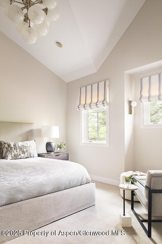 87 Thunderbowl Ln, Aspen, CO 81611 - bedroom featuring lofted ceiling, light carpet, and a chandelier