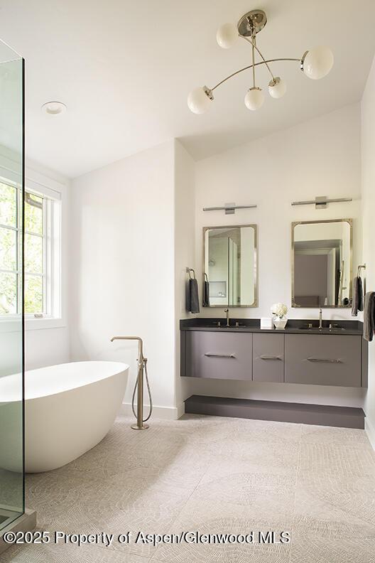 87 Thunderbowl Ln, Aspen, CO 81611 - full bathroom featuring double vanity, a soaking tub, vaulted ceiling, and a chandelier
