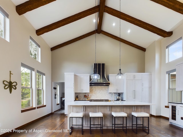 kitchen featuring ventilation hood, a breakfast bar area, light countertops, white cabinetry, and tasteful backsplash