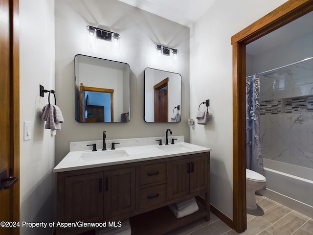 bathroom with a sink, toilet, shower / tub combo with curtain, and double vanity