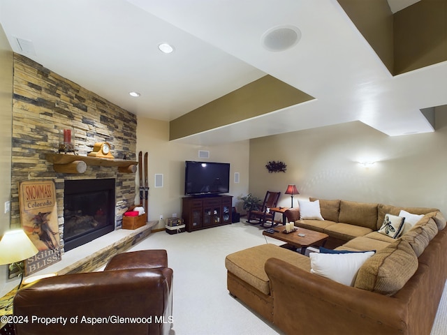 living area featuring a stone fireplace, recessed lighting, and carpet