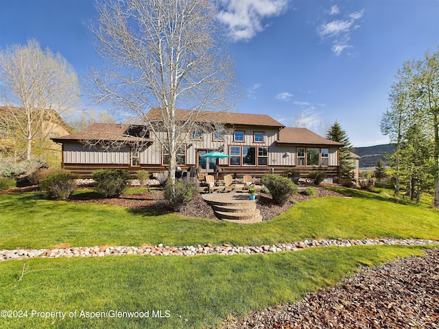 back of property featuring a lawn, a patio, and a deck