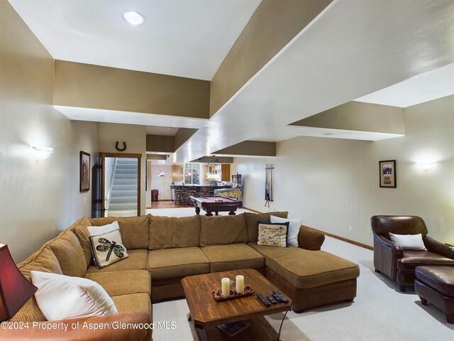 living area featuring light colored carpet and baseboards