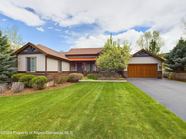 view of front of home with a garage, driveway, and a front yard