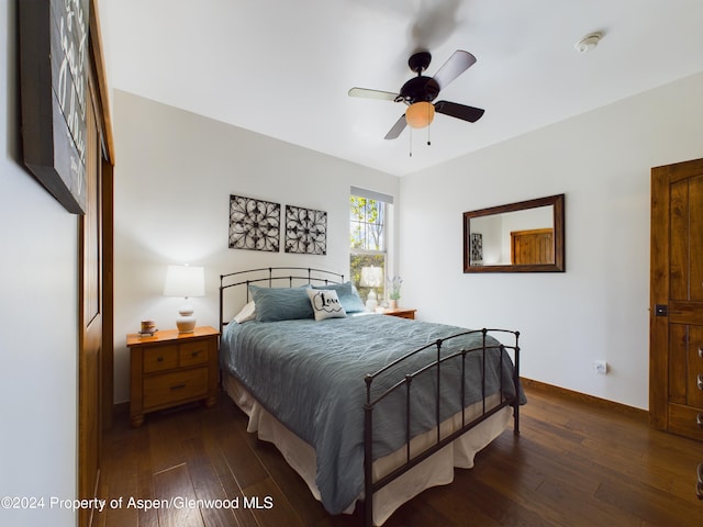 bedroom featuring ceiling fan, baseboards, and dark wood-style flooring