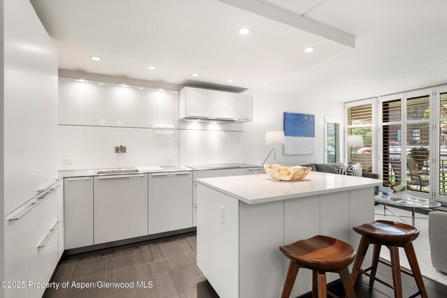 800 E Hopkins Ave Unit A-3, Aspen, CO 81611 - kitchen featuring modern cabinets, a kitchen bar, light countertops, white cabinetry, and a kitchen island