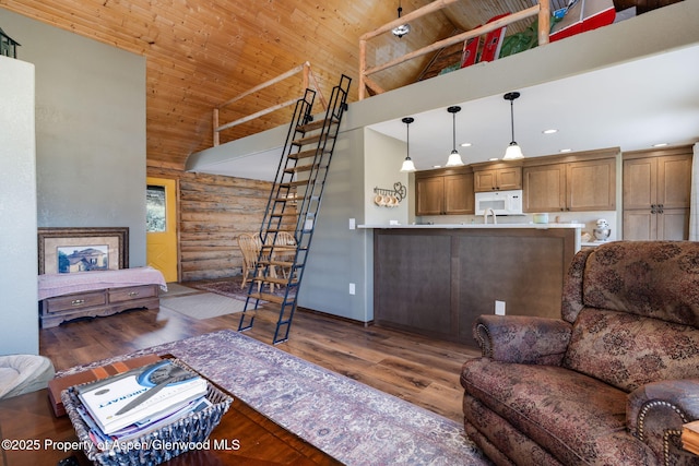 living room with high vaulted ceiling, recessed lighting, stairs, log walls, and dark wood-style floors