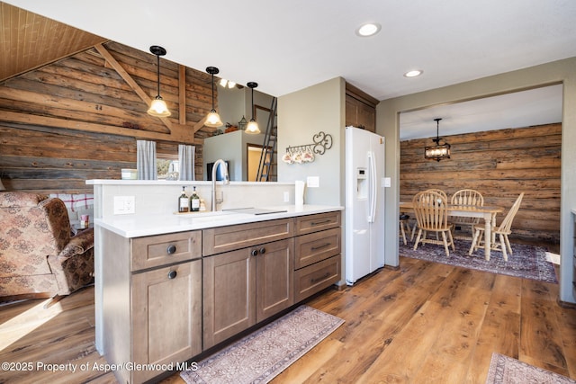 bathroom with vaulted ceiling, wooden walls, vanity, and wood finished floors