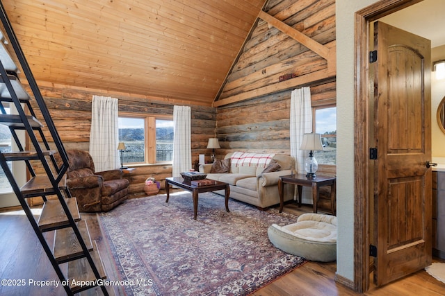 living area featuring high vaulted ceiling, wooden ceiling, log walls, and wood finished floors